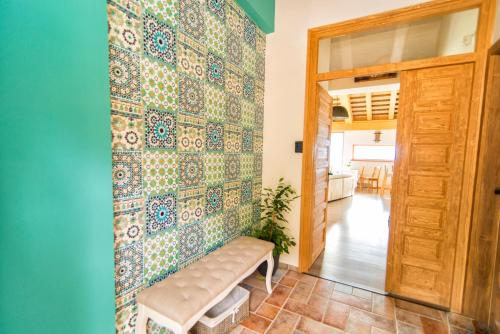 pokój z ławką i ścianą pokrytą płytkami w obiekcie Villa Terazza-Panorama Apartman w mieście Sümeg