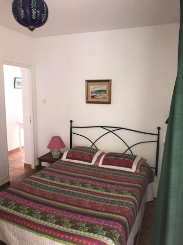 a bedroom with a bed with a colorful blanket at Jardin Andaluz veleta in Pinos del Valle