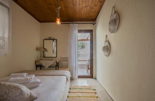 a bedroom with a bed and a door to a patio at Beach House Onar in Diaporos