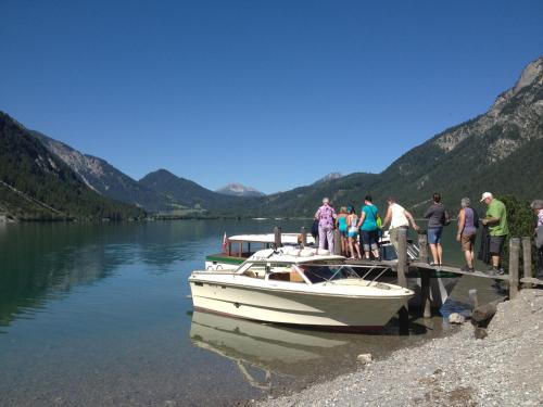 a group of people getting on a boat at a dock at Pension Posthansl in Heiterwang
