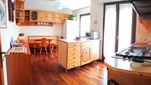 a kitchen with wooden floors and a kitchen with a table at L'Atelier du Temps - PanoramAlps Apartment in Courmayeur