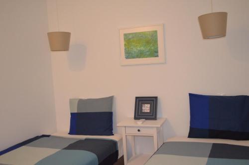 リスボンにあるFlor de Lis Residence - Alfamaのベッドルーム1室(ベッド2台付)が備わります。壁に絵が描かれています。