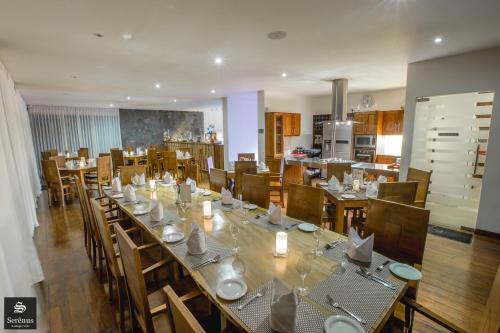 uma sala de jantar com uma mesa longa e cadeiras em Serenus Boutique Villa em Nuwara Eliya