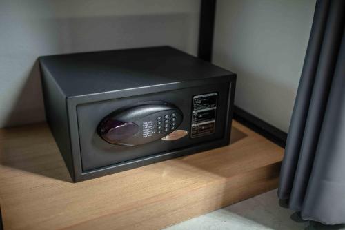 un horno microondas con mando a distancia sentado en un piso en M1 Hotel, en Nakhon Si Thammarat