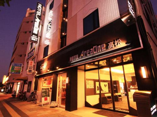 un magasin devant un bâtiment dans une rue la nuit dans l'établissement Hotel AreaOne Takamatsu, à Takamatsu