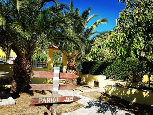 a street sign in front of a building with palm trees at B&B 500 Miglia  in Tempio Pausania