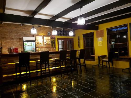 a bar with chairs and a table in a room at Port Del Mar Guesthouse in Hermanus