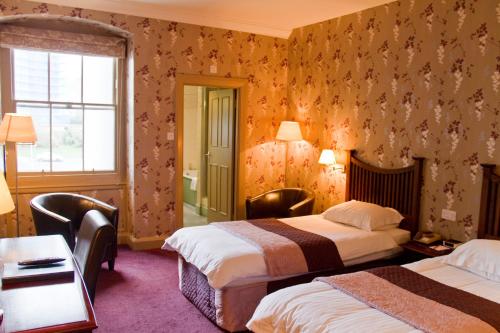 a hotel room with two beds and a window at Duke Of Cornwall Hotel in Plymouth