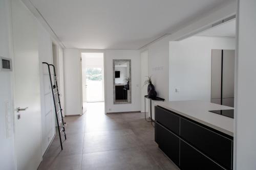 una cucina con pareti bianche e piano di lavoro nero di Einzigartiges Loft von Loftalive a Lollar