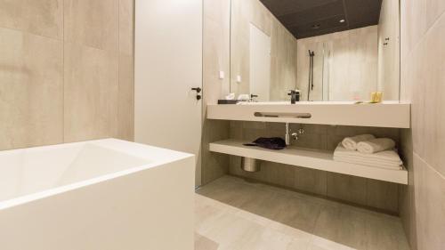 a bathroom with a white tub and a sink and a bath tub at Park Hotel Viljandi in Viljandi
