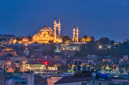 a view of a city at night with a mosque at Galatower Hotel in Istanbul