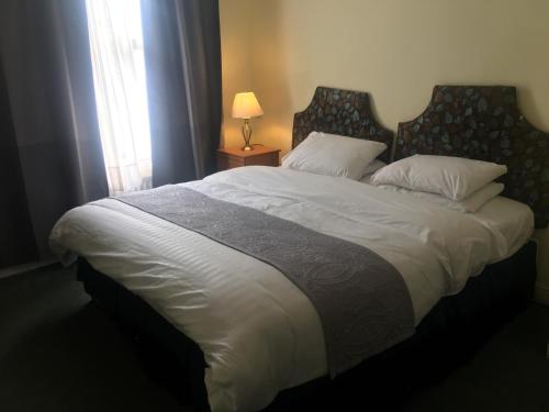 a large bed in a bedroom with a window at Dukes Head Inn in Richmond upon Thames