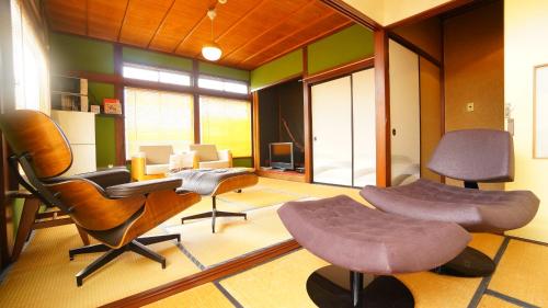 a living room with two chairs and a table at Super Tomato House Takayama in Takayama