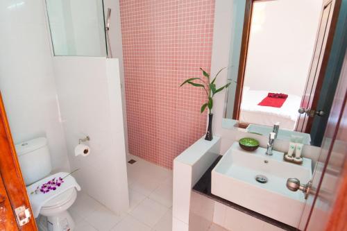 uma casa de banho com um lavatório, um WC e um espelho. em Suite Home Boutique Hotel em Phnom Penh