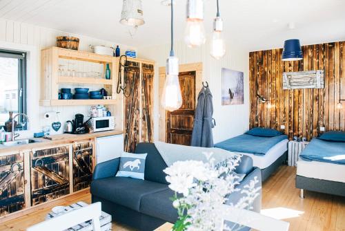 ein Wohnzimmer mit einem blauen Sofa und einer Küche in der Unterkunft Akurgerði Guesthouse 4 - Country Life Style in Ölfus