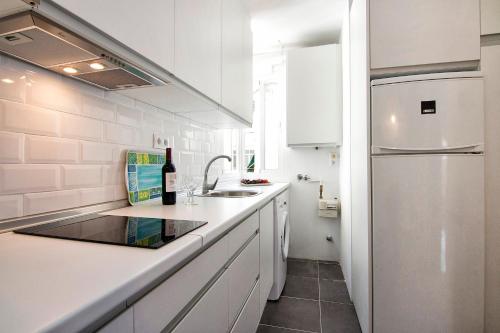 グラナダにあるtuGuest Aben Humeya Apartmentの白いキッチン(シンク、冷蔵庫付)