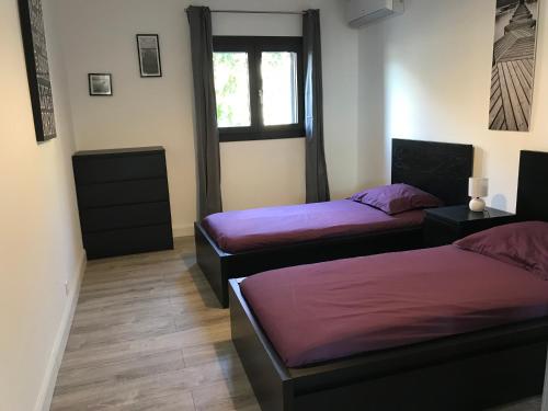 deux lits dans une chambre avec une fenêtre dans l'établissement Appartement 80m2 dans Villa, à Propriano