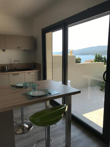 une cuisine avec une table et une vue sur l'océan dans l'établissement Appartement 80m2 dans Villa, à Propriano