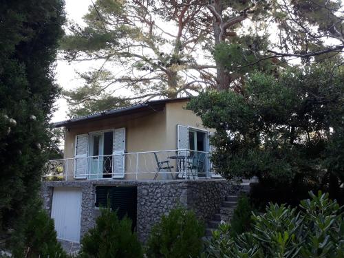 a house with a balcony and trees at Holiday Home Paradizo in Veli Lošinj