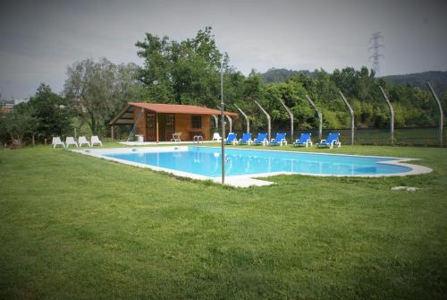 a swimming pool with chairs and a building at Quinta do Galgo in Amares