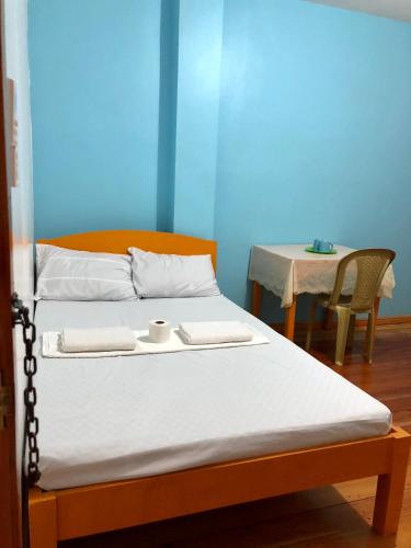 a bed in a room with a table and a bed sidx sidx sidx at Michelina Princess Guest House in Loboc