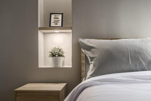 a bedroom with a bed and a window with a pot of flowers at Carnation Residence in Samut Prakan