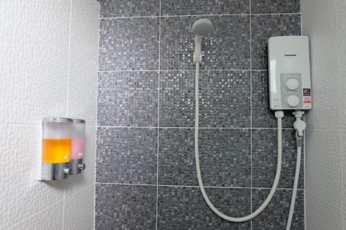 a shower in a bathroom with a shower head at DOS'S HOUSE in Nai Yang Beach