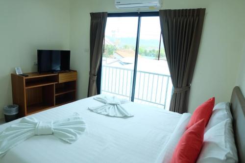 a bedroom with a bed and a balcony with a television at DOS'S HOUSE in Nai Yang Beach