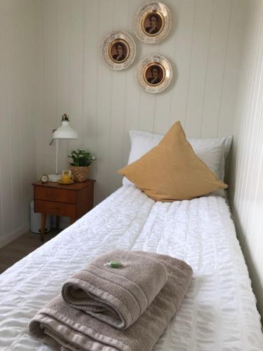 una camera da letto con un letto e asciugamani di Olsens Pensjonat a Veiholmen