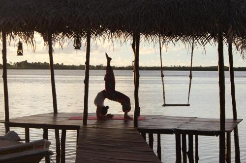 a woman doing yoga on a dock on the water at Anawasal in Kalpitiya