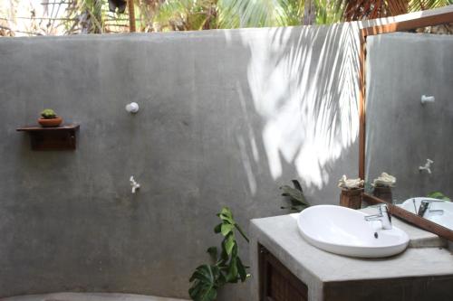 a bathroom with a sink and a concrete wall at Anawasal in Kalpitiya