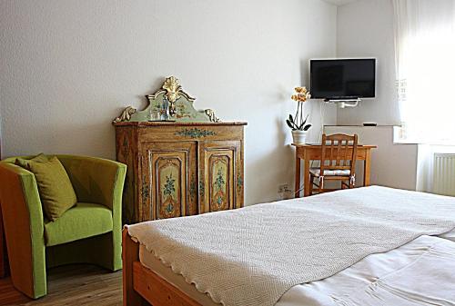 a bedroom with a bed and a chair and a tv at Schloß Destille in Dormagen