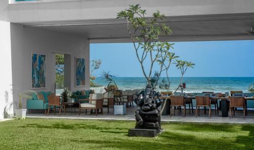a statue in the middle of a restaurant with the ocean at Sielen Diva in Unawatuna