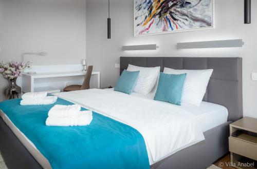 a large bed with blue and white sheets and pillows at Villa Anabel in Hvar
