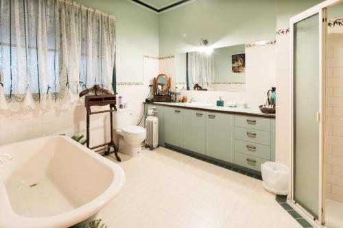 a bathroom with a tub and a sink and a toilet at Rustic Refuge Guesthouse in Kalorama