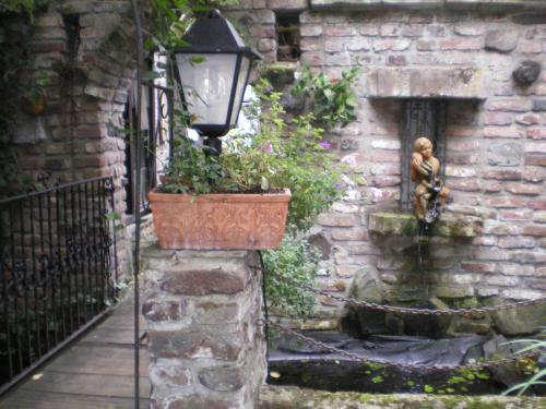 a street light with a statue next to a brick wall at Schloß Destille in Dormagen