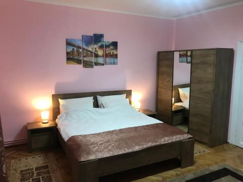 een slaapkamer met een bed met 2 lampen en een spiegel bij Casa TRANSILVANIA in Oradea
