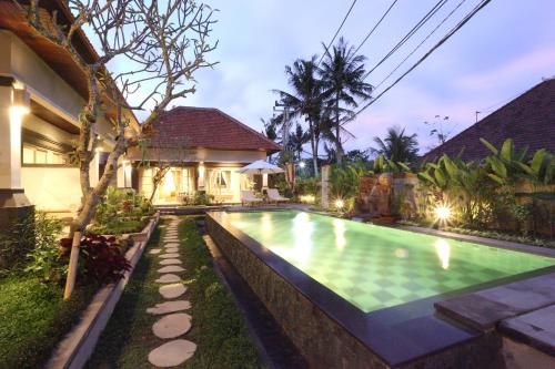 a swimming pool in the backyard of a house at Uma Dhari Villa by Prasi in Ubud