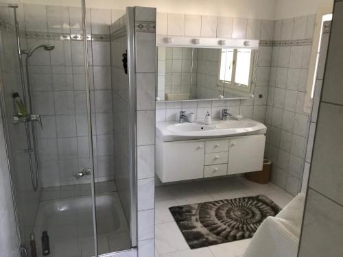 uma casa de banho com um chuveiro, um lavatório e um espelho. em Casa al Castagno em Gambarogno