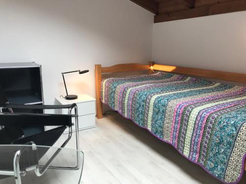 a bedroom with a bed with a lamp and a tv at Casa al Castagno in Gambarogno