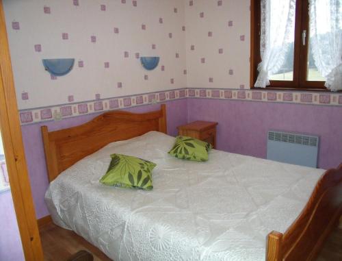 a bedroom with a bed with green pillows on it at Gîte Les Hirondelles in Plombières-les-Bains