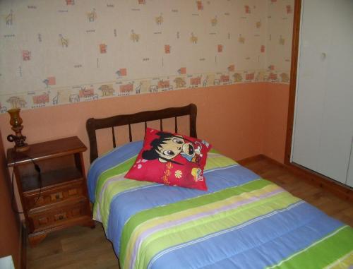 a bedroom with a bed with a pillow on it at Gîte Les Hirondelles in Plombières-les-Bains