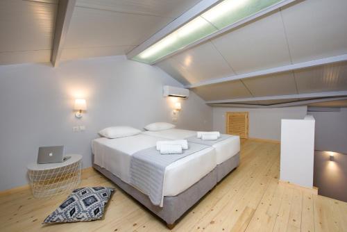 a bedroom with a large bed with a laptop on it at La Soffitta in Benitses