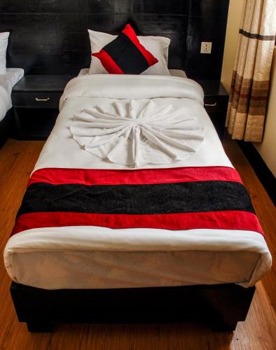 a bed with a red black and white blanket on it at Kathmandu Regency Hotel in Kathmandu