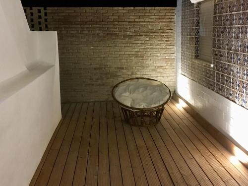 a basket sitting on a wooden floor with a brick wall at MantaGarden in Manta Rota