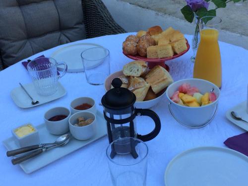 une table blanche avec une plaque de nourriture dans l'établissement Chambre côté jardin, à Nîmes