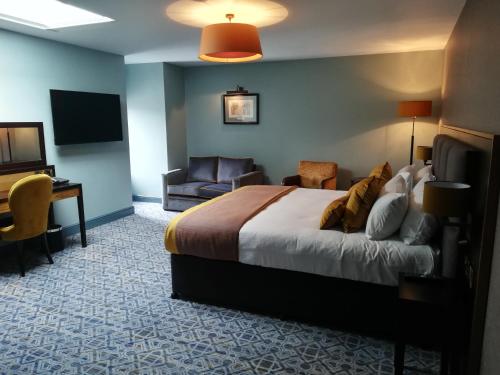 a hotel room with a bed and a desk and a television at The Old Borough Hotel - Wetherspoon in Swords