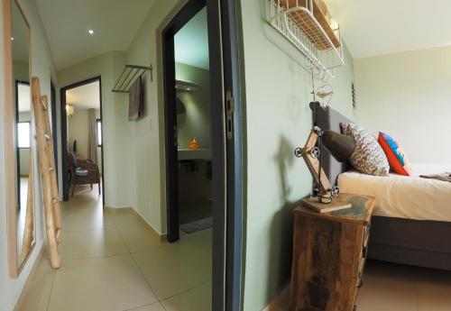 a room with a bed and a hallway with a mirror at Oasis guesthouse, Boutique Style Hotel in Kralendijk