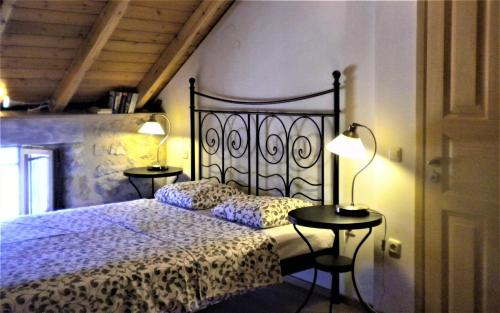 a bedroom with a bed and two tables with lamps at Stone House in a quiet landscape, Leonidion in Leonidion
