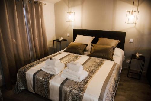 a bedroom with a bed with towels on it at La Suite Romantique avec Jacuzzi au Cœur de Perpignan in Perpignan